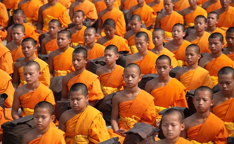 Buddhist monks wearing orange robes as a symbol of simplicity and detachment.