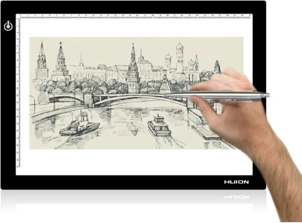Person using a Huion lightbox to draw a landscape sketch
